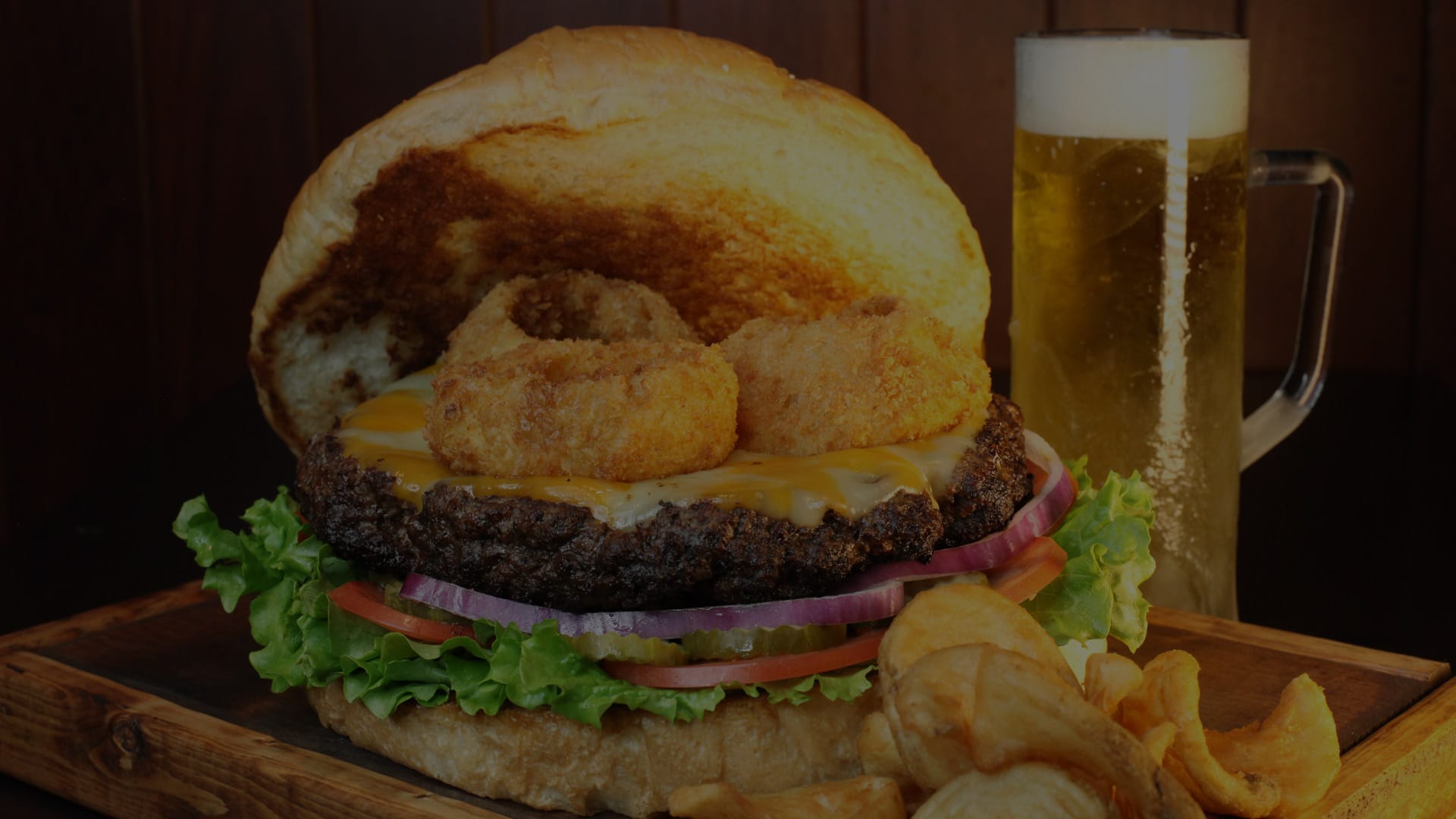 A cheesburger with onions rings on it, prepared by Wallbangers